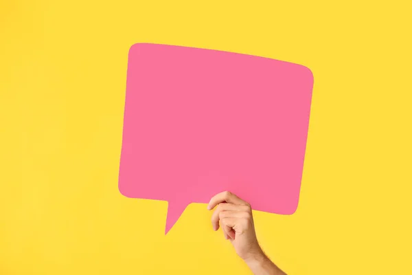 Female hand with blank speech bubble on color background — Stock Photo, Image