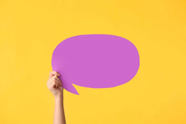 Female hand with blank speech bubble on color background — Stock Photo, Image