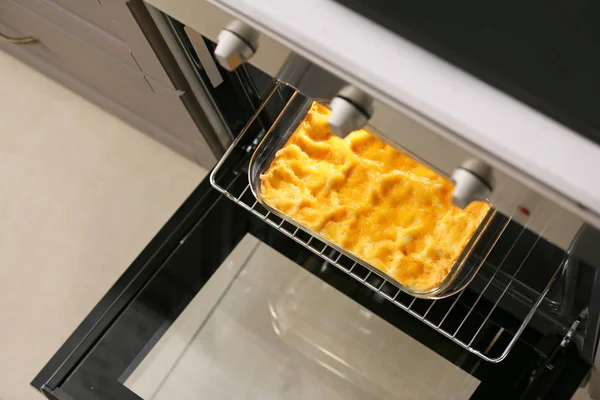 Baking dish with prepared lasagna in open oven — Stock Photo, Image