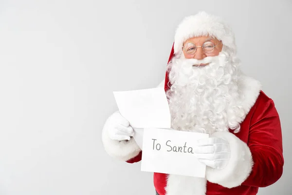 Санта-Клаус с письмом на светлом фоне — стоковое фото