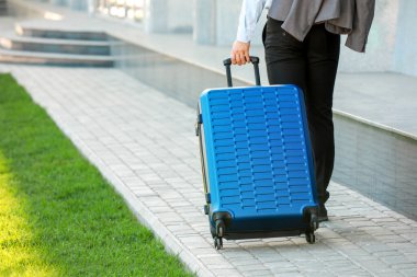 İş gezisi için bavulları olan genç bir adam.