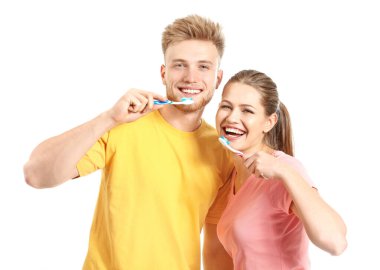 Beyaz arka planda dişlerini fırçalayan genç çift