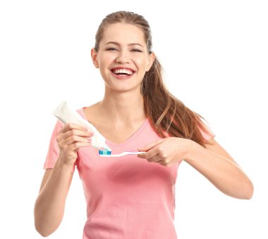 Beyaz arka planda diş fırçası ve yapıştırıcısı olan genç bir kadın.