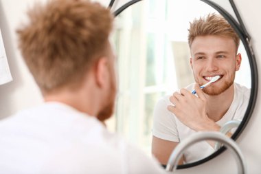 genç adam evde diş fırçalama