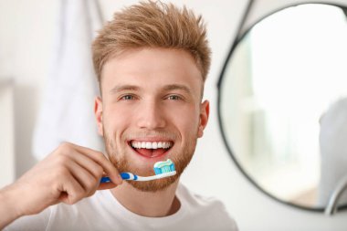 genç adam evde diş fırçalama