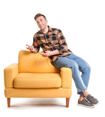 Beyaz arka planda oturan yakışıklı adam.