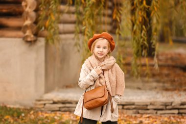 Dışarıda sonbahar kıyafetleri içinde şirin küçük bir kız.