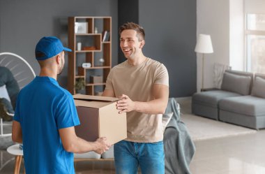 Evdeki kurye servisinden paket alan adam