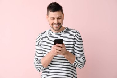 Renkli arka planda cep telefonu olan mutlu adam