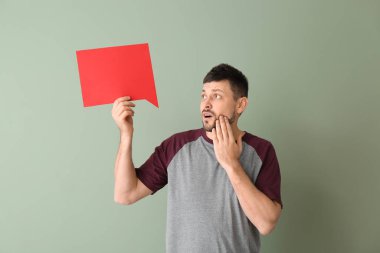 Renk arkaplanında boş konuşma balonuyla şok olmuş bir adam