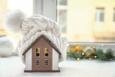 Pencere pervazında şapkası olan bir model. Kış konsepti
