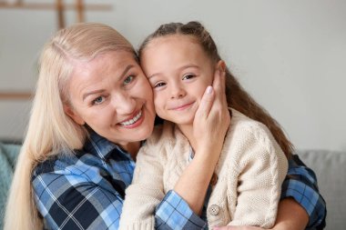 Küçük kız ve büyükanne evde birlikte vakit geçiriyorlar.