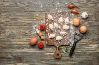 Ahşap zemin üzerinde çiğ hamur köftesi ve malzeme olan tahta.