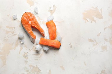 Hafif arkaplanda taze çiğ somon ve buz küpleri.