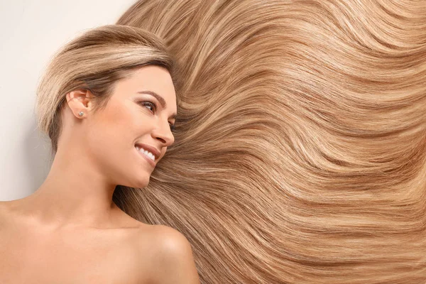 Hermosa mujer joven con cabello largo y saludable sobre fondo blanco —  Fotos de Stock