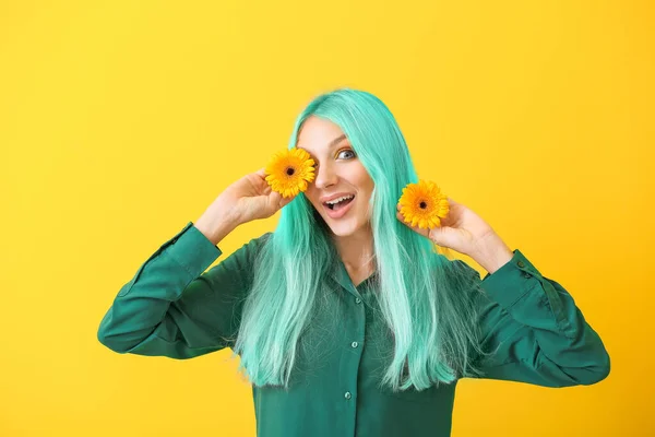 Hermosa mujer joven con pelo teñido inusual y flores de gerberas en el fondo de color —  Fotos de Stock