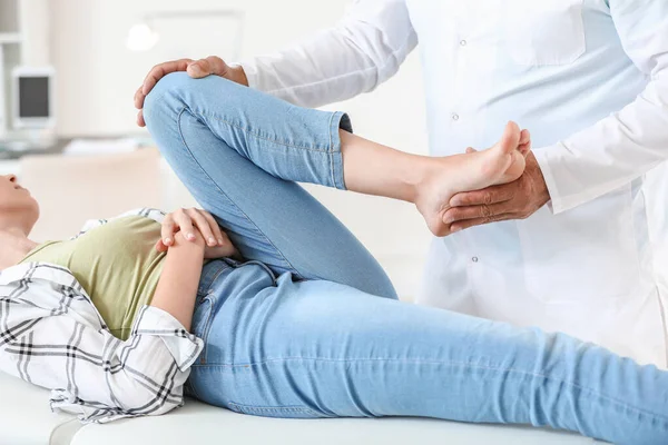 Doctor examining young woman with joint pain in clinic — Stock Photo, Image