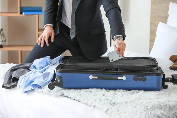 Young man packing things for business trip at home — Stock Photo, Image