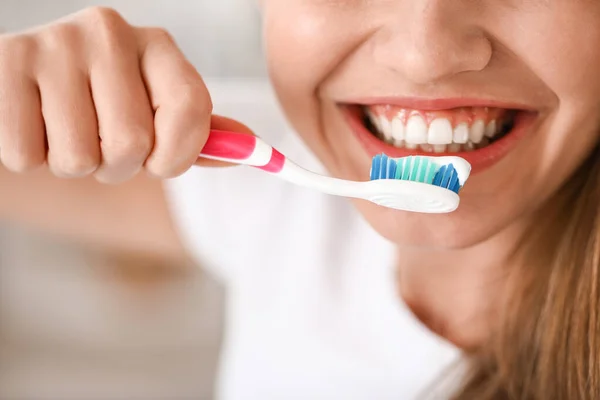 Jovem mulher escovar os dentes em casa, close-up — Fotografia de Stock