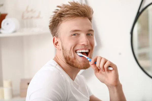 Young man brushing teeth at home — Stock Photo, Image