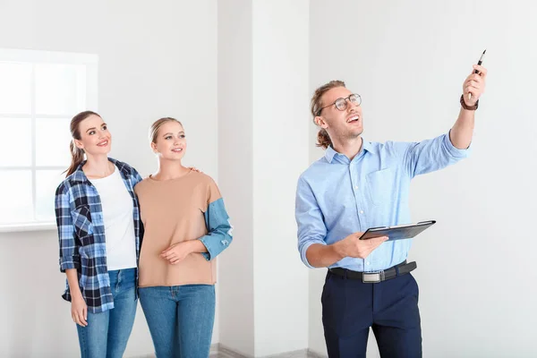 Real estate agent showing lesbian couple a new house — Stock Photo, Image