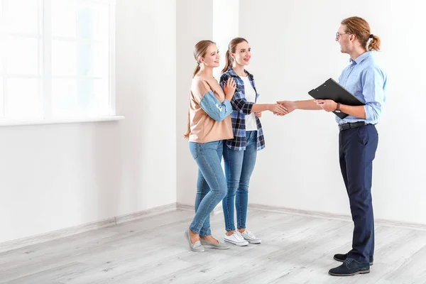 Frau schüttelt Immobilienmakler drinnen die Hand — Stockfoto