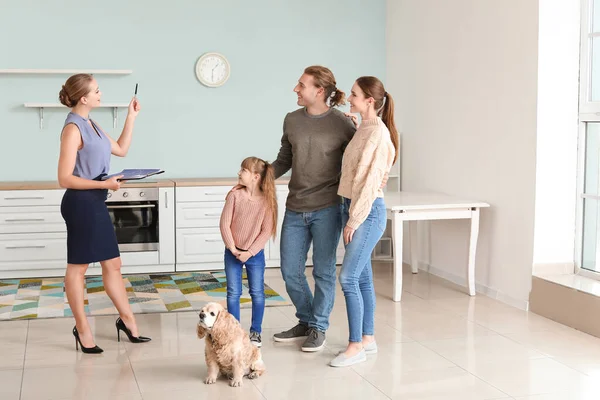 Agente immobiliare mostrando giovane famiglia una nuova casa — Foto Stock