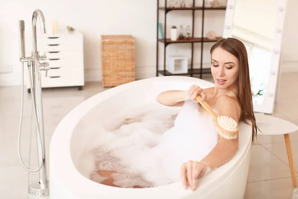 Schöne junge Frau beim Waschen in der Badewanne — Stockfoto