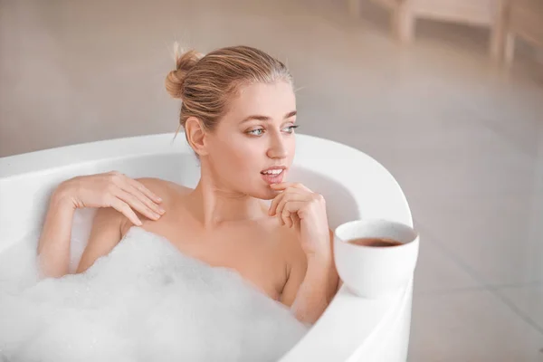 Schöne junge Frau entspannt sich im Badezimmer — Stockfoto