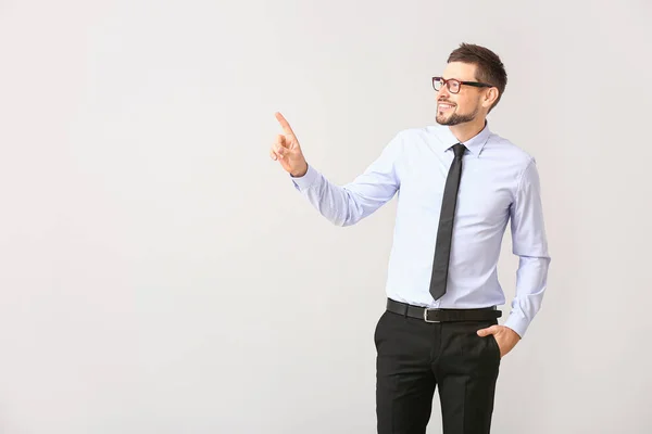 Stilig affärsman pekar på något på vit bakgrund — Stockfoto