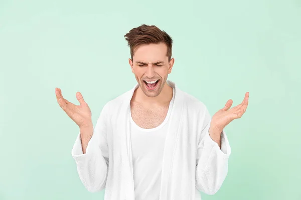 Happy man in bathrobe on color background — Stock Photo, Image