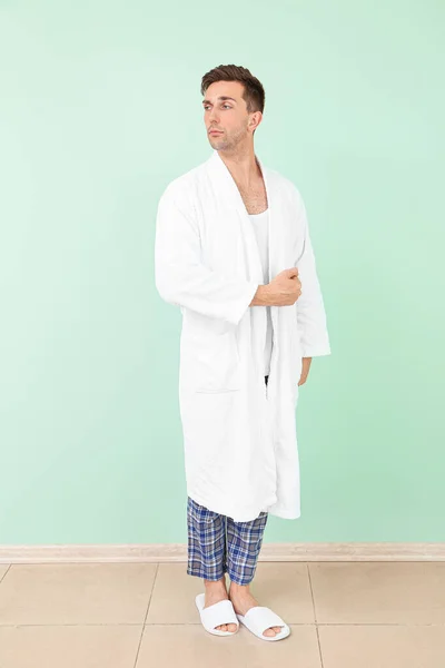 Handsome man in bathrobe near color wall — Stock Photo, Image