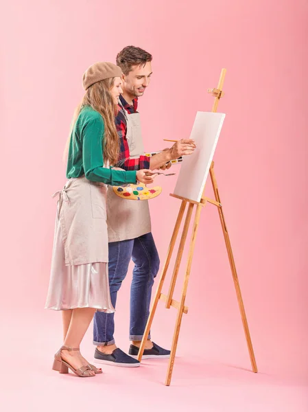 Paar junger Künstler auf farbigem Hintergrund — Stockfoto
