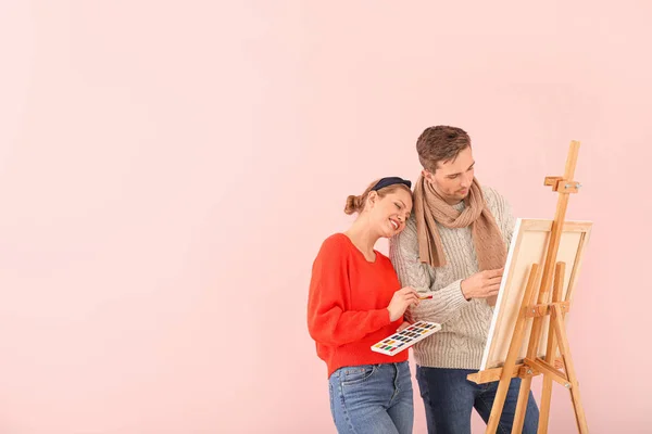Paar junger Künstler auf farbigem Hintergrund — Stockfoto