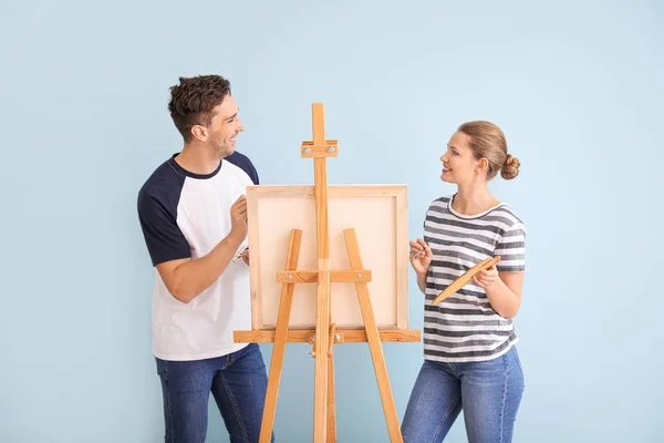 Couple of young artists on color background — Stockfoto