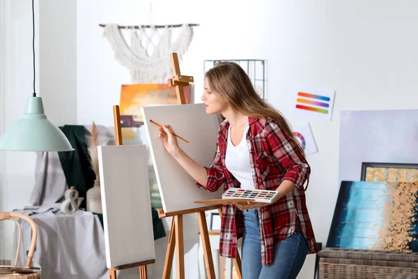 Молодая художница рисует в студии — стоковое фото