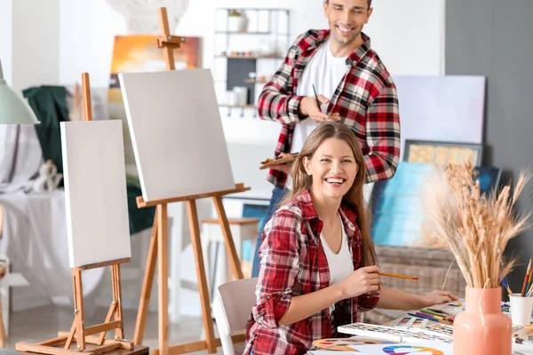 Pareja de jóvenes artistas trabajando en el estudio —  Fotos de Stock