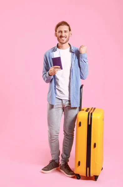 Young tourist with luggage on color background — Stock Photo, Image