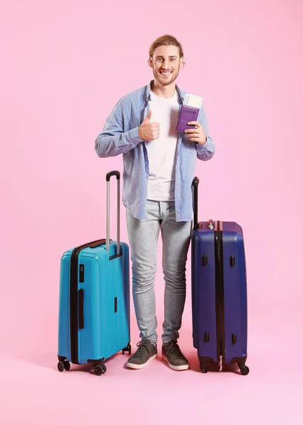 Young tourist with luggage on color background — Stock Photo, Image