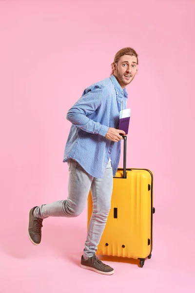 Hurrying tourist with luggage on color background — Stock Photo, Image