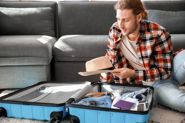 Young man packing luggage at home — Stock Photo, Image