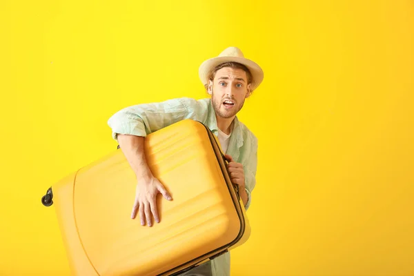 Apresse-se turista masculino com bagagem no fundo de cor — Fotografia de Stock