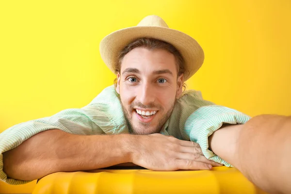 Fiatal férfi turista poggyász színes háttér — Stock Fotó
