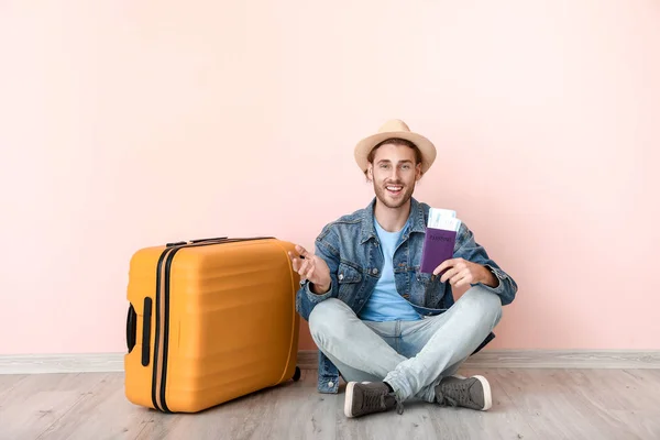 Young male tourist with luggage near color wall — 스톡 사진