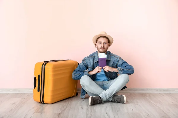 Young male tourist with luggage near color wall — Stock Photo, Image