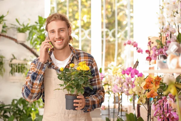 Portrait of male florist talking by phone in shop — Stock Photo, Image