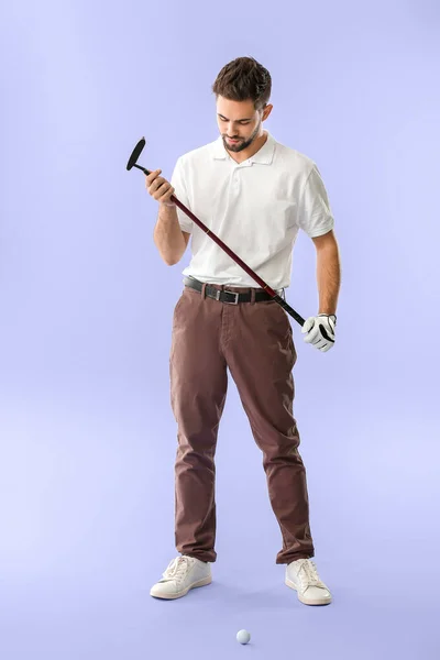 Schöner männlicher Golfer auf farbigem Hintergrund — Stockfoto