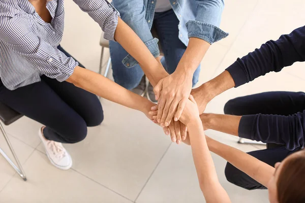 Jóvenes poniendo manos juntas durante la sesión de apoyo psicológico —  Fotos de Stock