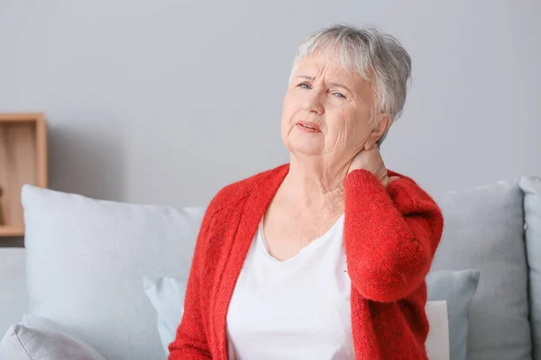 Mulher idosa que sofre de dor no pescoço em casa — Fotografia de Stock