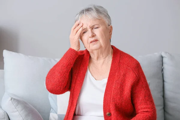 Mujer mayor que sufre de dolor de cabeza en casa — Foto de Stock